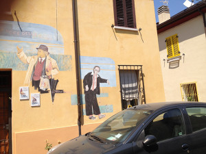 Sopra il 38 di Via Marecchia, nel Borgo san Giuliano, il “murales” che raffigura Benigni e Villaggio (e non Fellini)